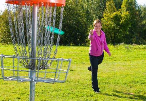 woman throwing discgolf at a target