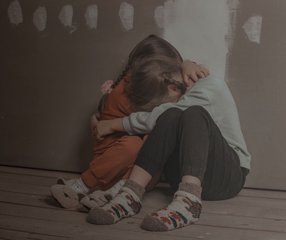 Scared kids holding each other.