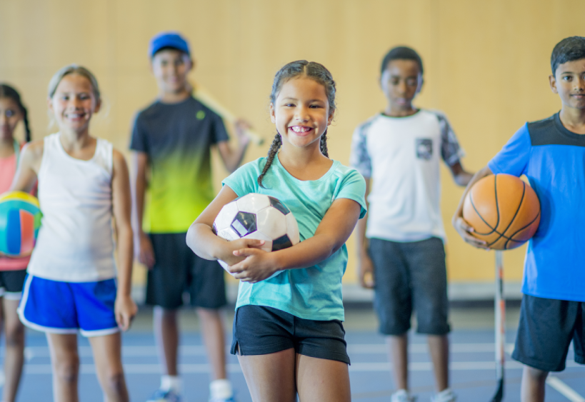 kids holding various sports equipment