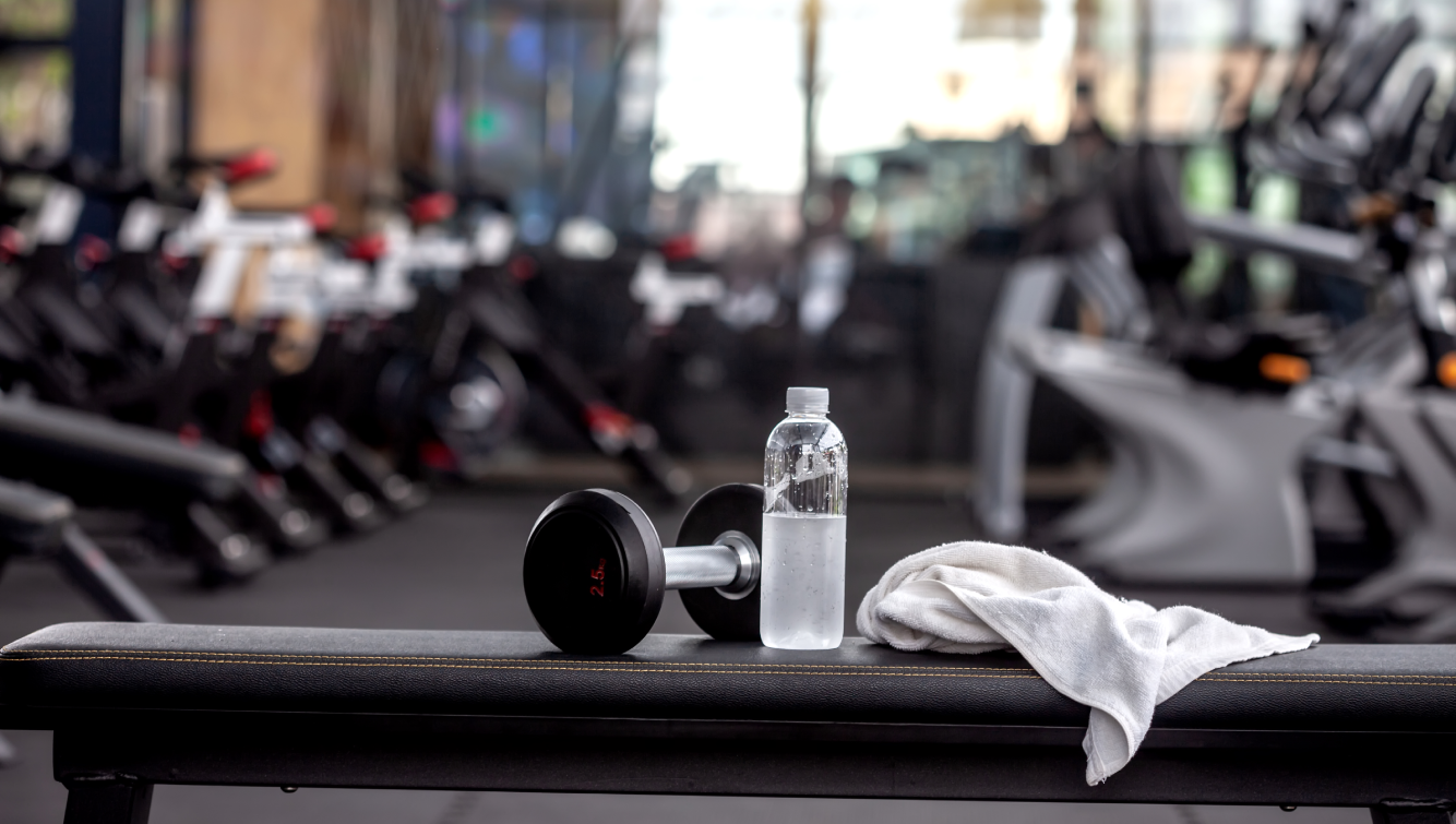 water bottle and dumbbell on a bench