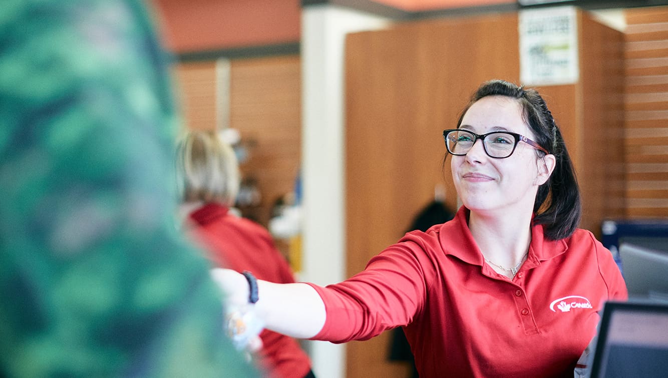 Female Canex Staff member assists customer