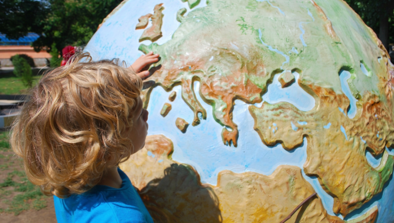 A child exploring a colourful globe.