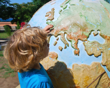 A child exploring a colourful globe.