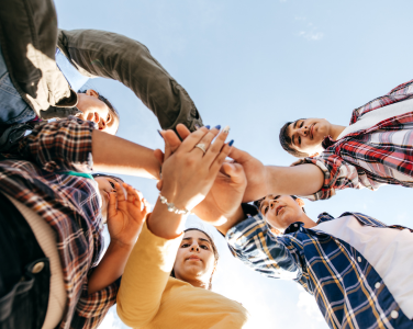 A group of teens standing in a circle.