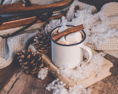 A mug of hot chocolate in a cozy, winter scene.