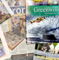 An Image of various issues of the Aurora Newspaper and the Wing Guide arranged over eachother.