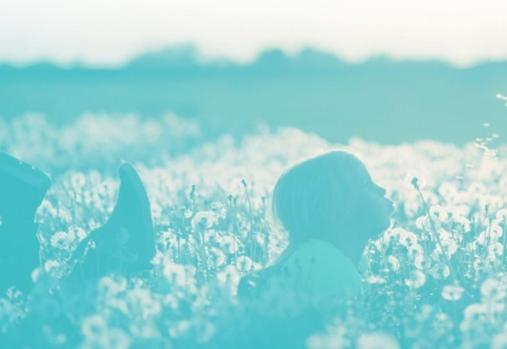 girl blowing a dandelion