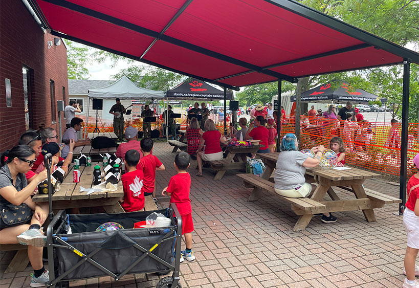 Happy family, picnic and summer, fun in park with children and parents bonding and playing on grass.
