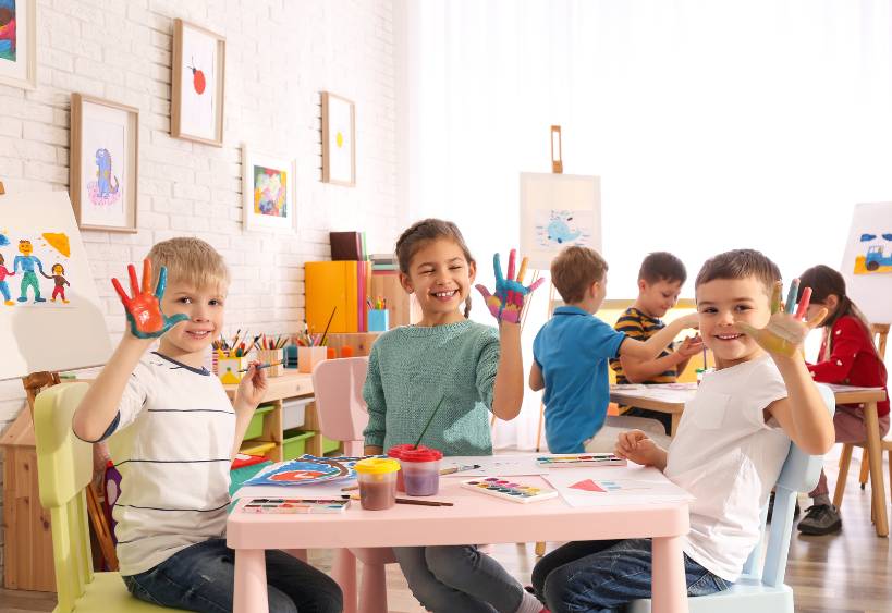Cute Little Children with Painted Palms in Room