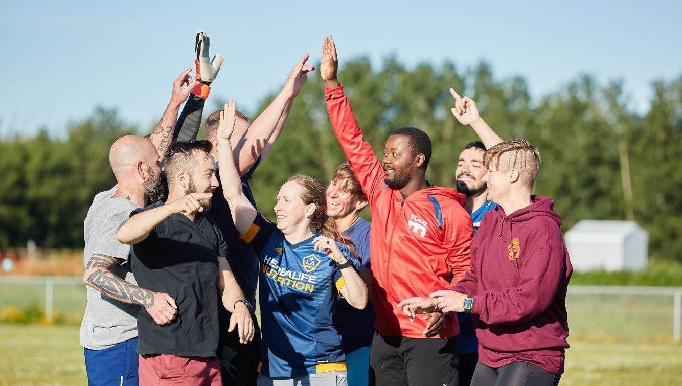 CAF members in sport attire giving each other high fives 