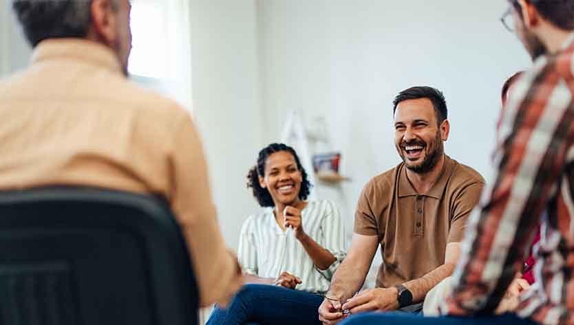 People smiling in a support group meeting