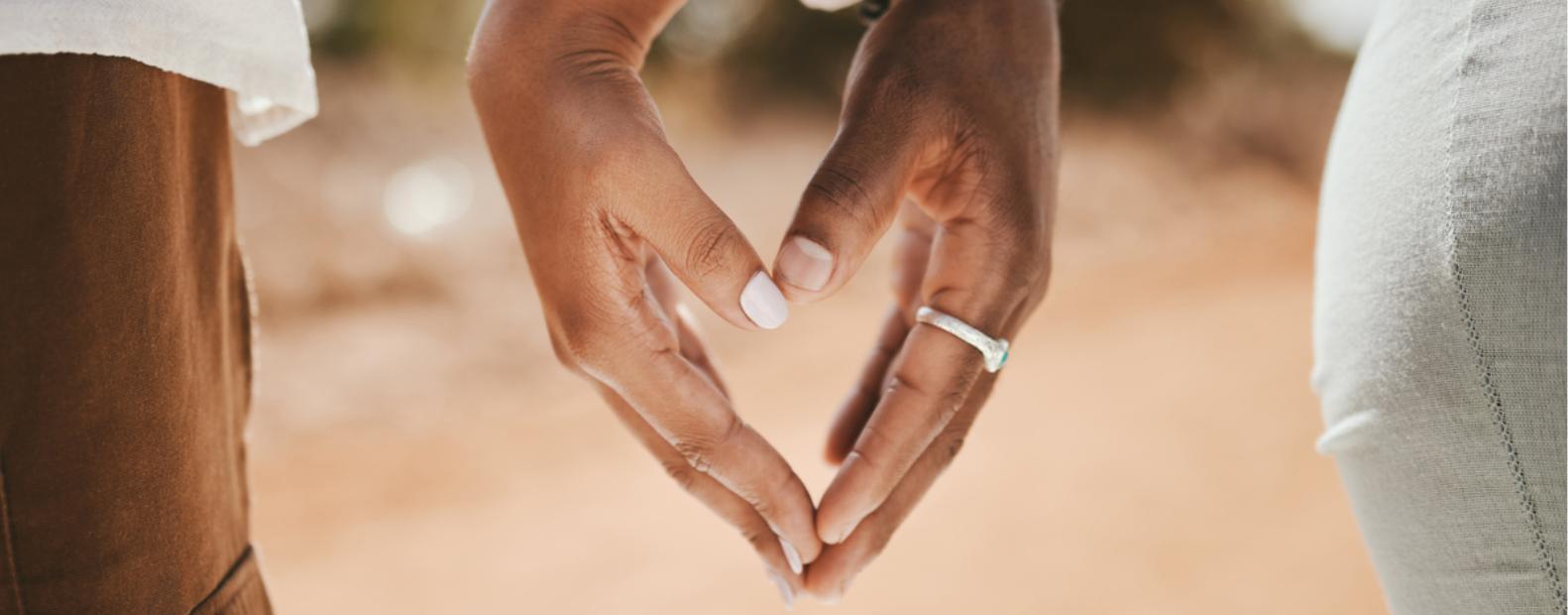 Couple creating a shape of a heart with their hands