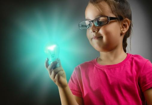 Little girl holding teal coloured light bulb that is shining brightly