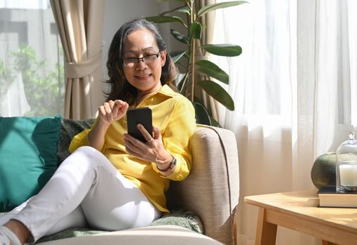 woman sitting on a couch looking at phone