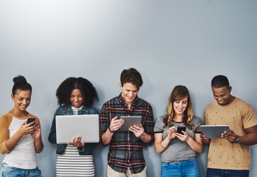 five youth in a row looking at devices