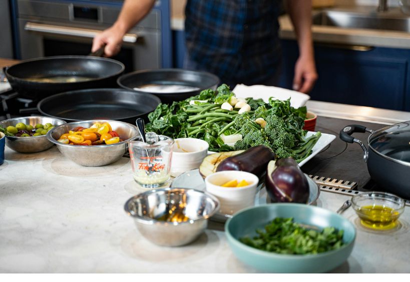 Fresh ingredients and cooking utensils are arranged on a countertop, ready for meal preparation.