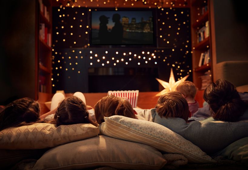 A family laying on the floor watching a movie
