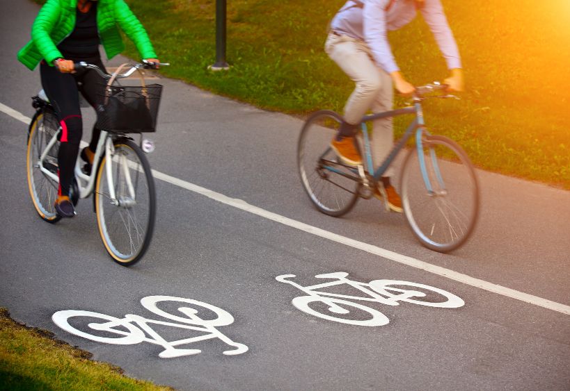 Two people are riding bicycles on a designated bike path.