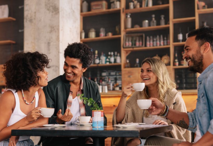 Four people are chatting together in a coffee shop.