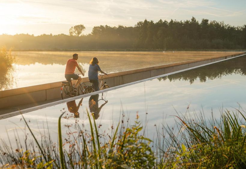 People cycling on a path through water