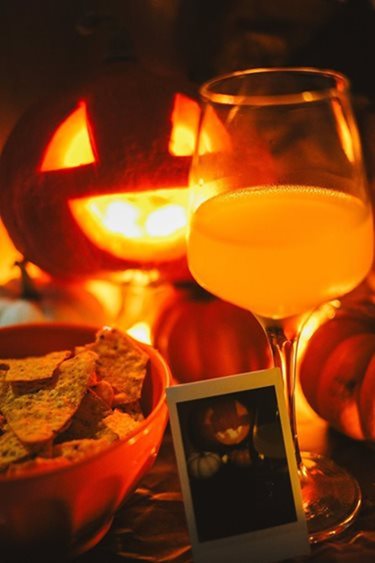 Jack-o-lantern with chips, drink, and photo