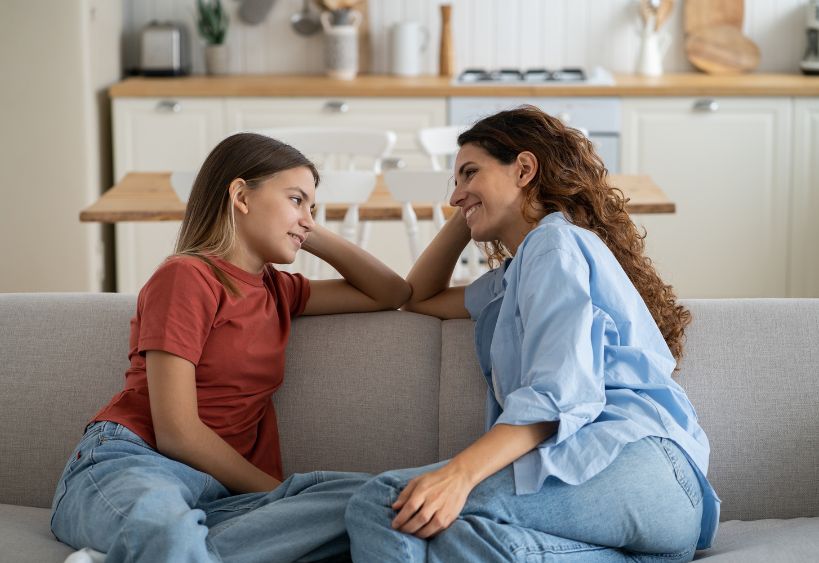 woman and teen sitting on couch together
