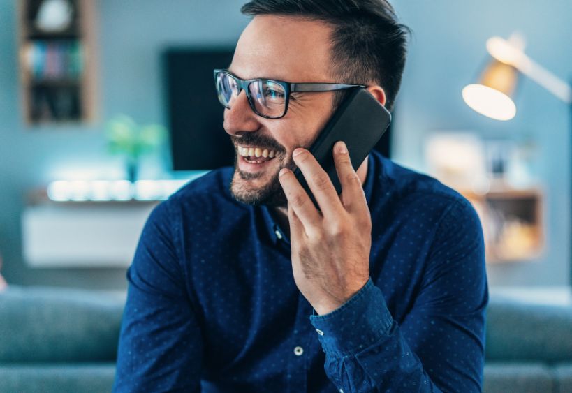 man smiling and talking on phone 