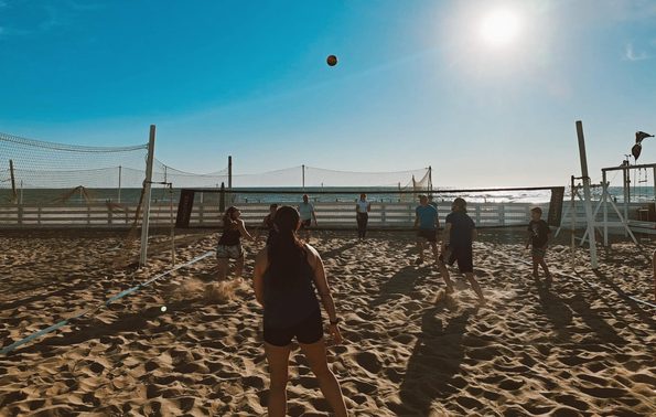 people playing volleyball on a beach