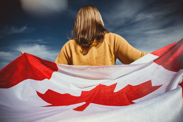 back of a woman with a Canadian flag wrapped around her