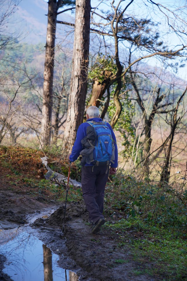 Man hiking on a muddy forest trail