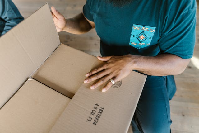 Close-Up Shot of a Person Holding a Cardboard Box