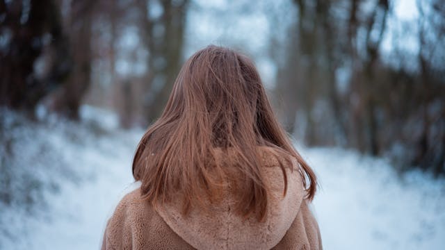 back of woman looking down a snowy path