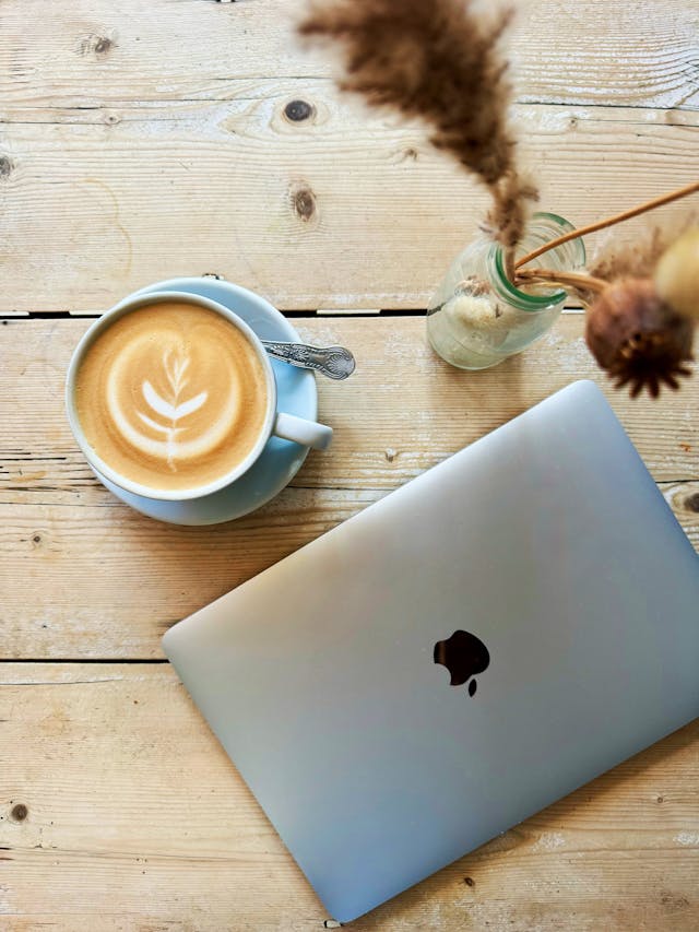 latte on wooden table next to laptop