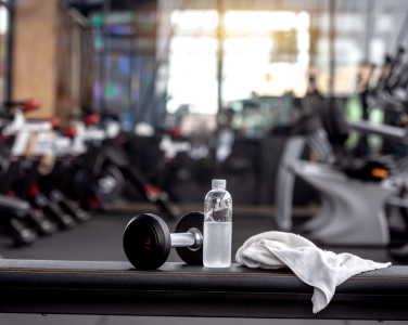 water bottle, towel & weight on a bench