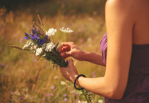 a woman holding some wild flowers