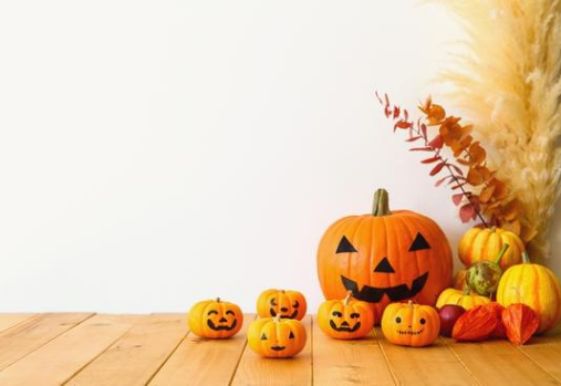 pumpkins with faces painted on them, on the floor in the corner of a room