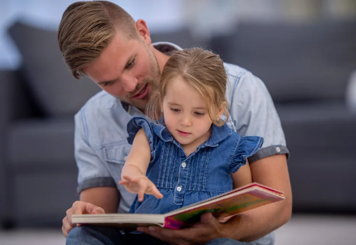 dad and young child reading a book 