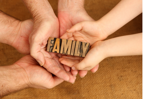 3 sets of hands holding the word FAMILY made out of wood