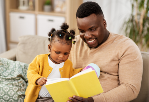 dad and young child reading a book 