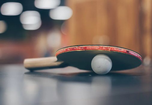 ping pong paddle on top of a ping pong ball