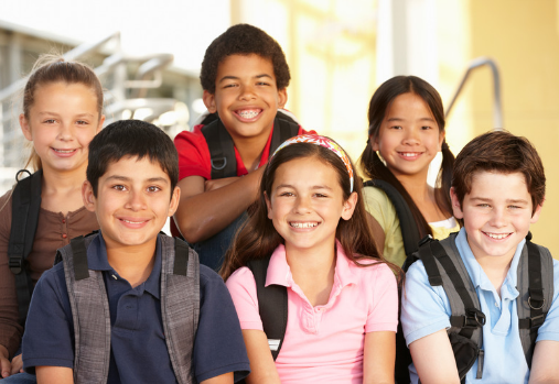 A group of preteens sitting and smiling at the camera