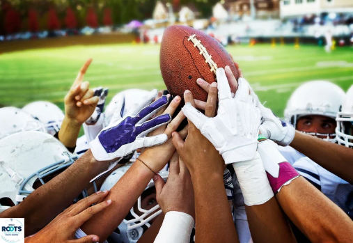 football players holding a football up together