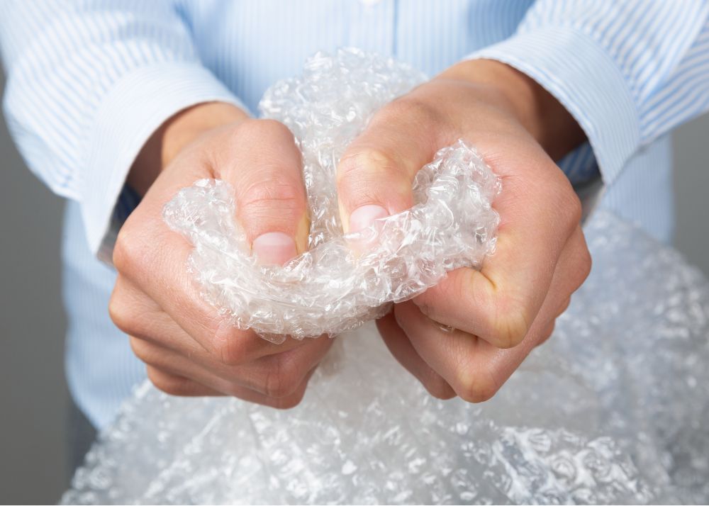 Two hands squeezing bubble wrap.