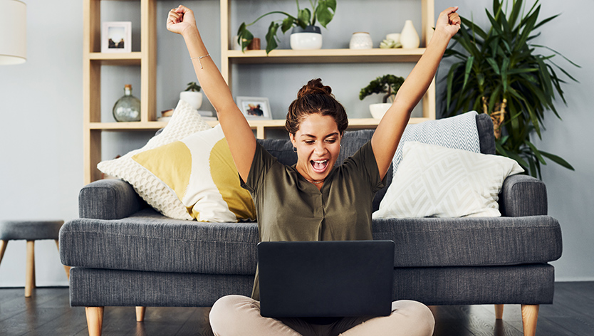 excited woman looking at laptop