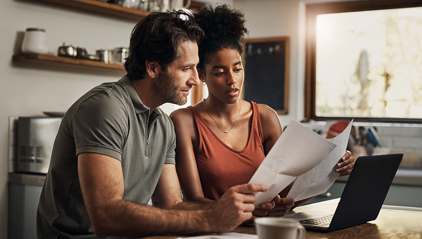 couple looking at paperwork and computer