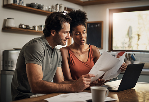 couple at kitchen table looking at paperwork