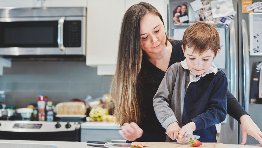 A mother and her son cutting strawberries