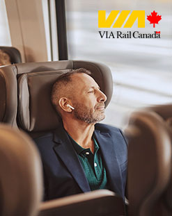 Man riding in train, VIA logo