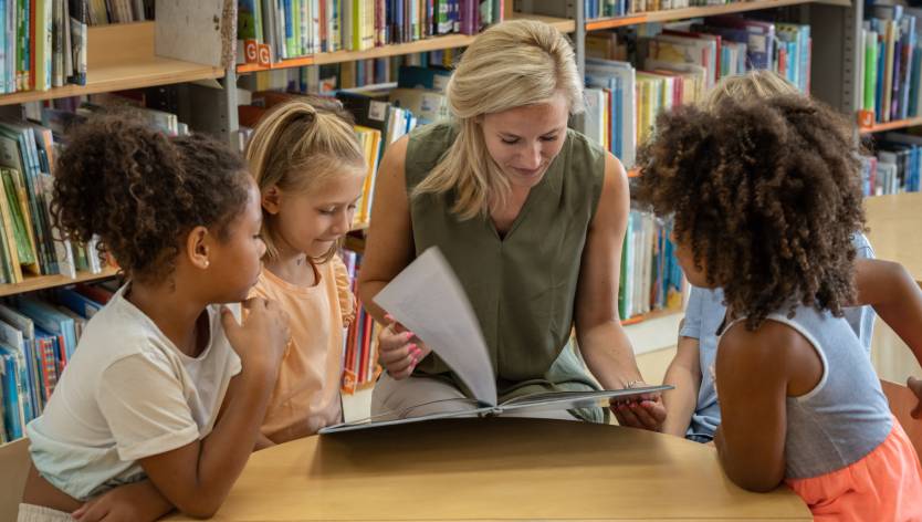 Women looking at books with children