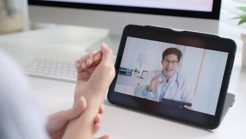 woman holding wrist & virtual doctor